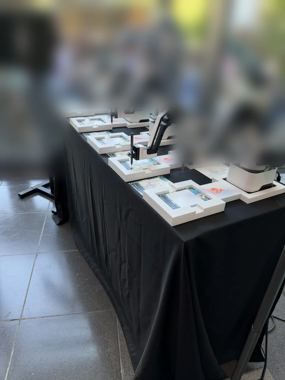 Fünf KI Zeichenroboter mit „Draw Me Bot"-Aufsteller bei einem lebhaften Sommerfest in Leinfelden-Echterdingen