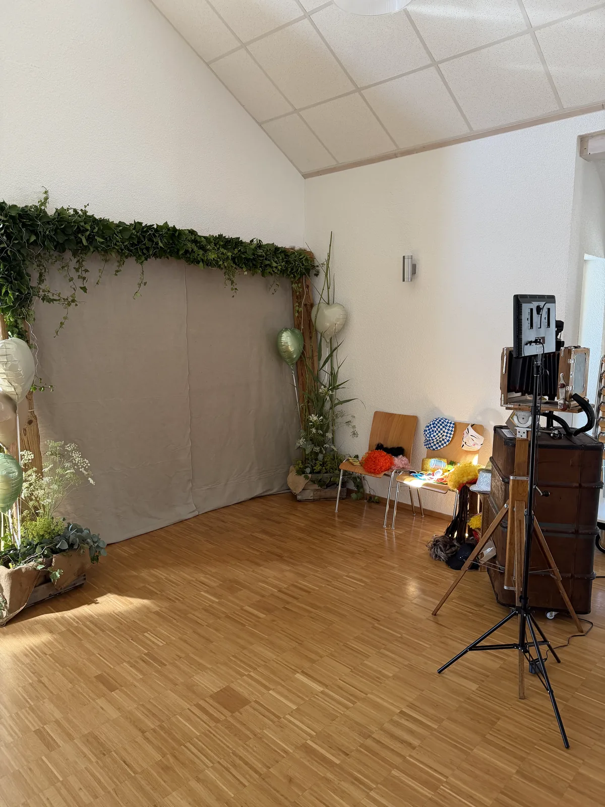 Vintage Fotobox aus Überseekoffer und Plattenkamera vor einer mit Efeu und Ballons dekorierten Kulisse beim Musikverein Bisingen