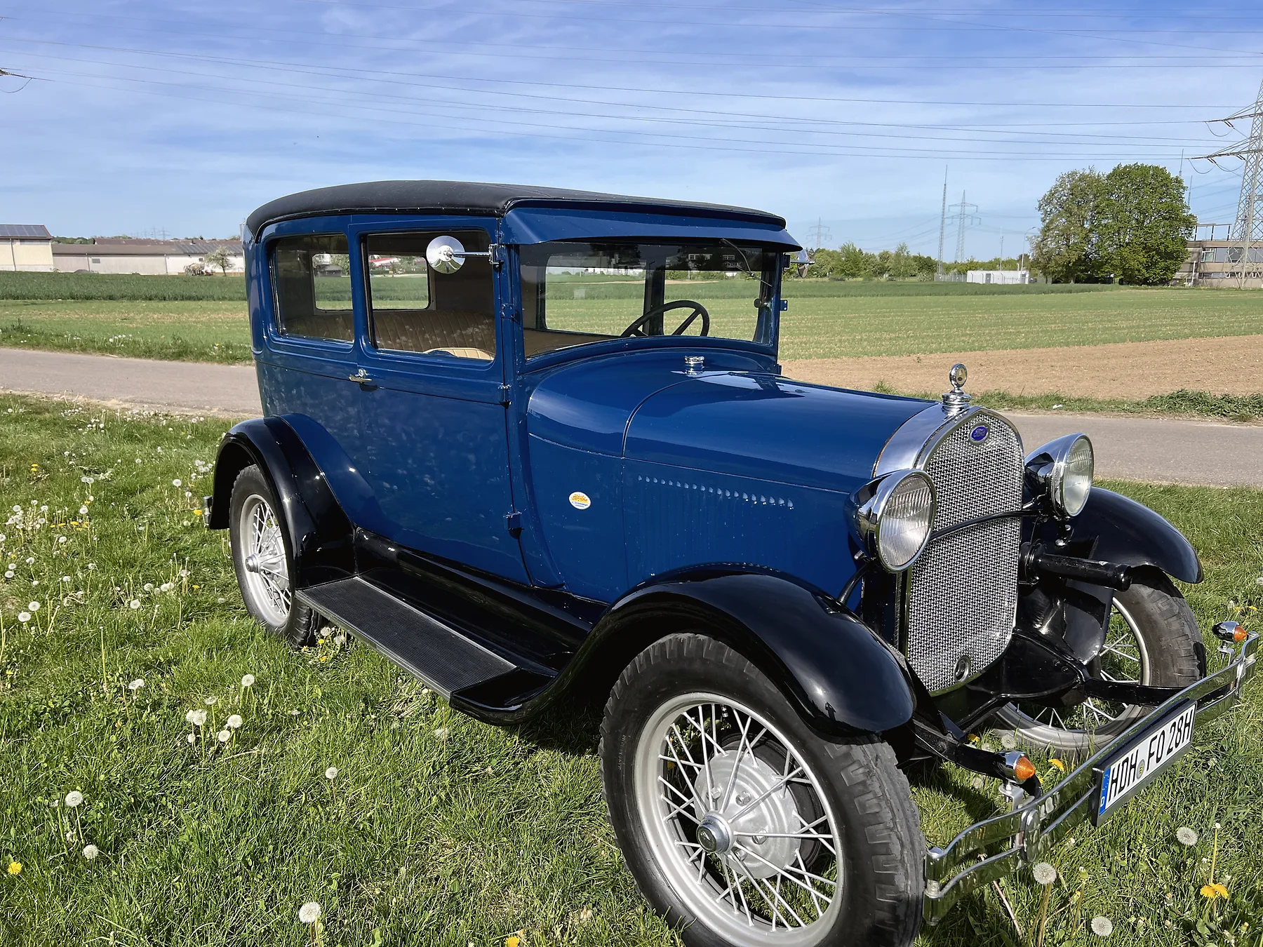 Ford Model A 1928 in Kobaltblau im Wiesenfeld